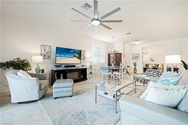 Living room with a chandelier, a ceiling fan, and light tile patterned flooring | Image 11