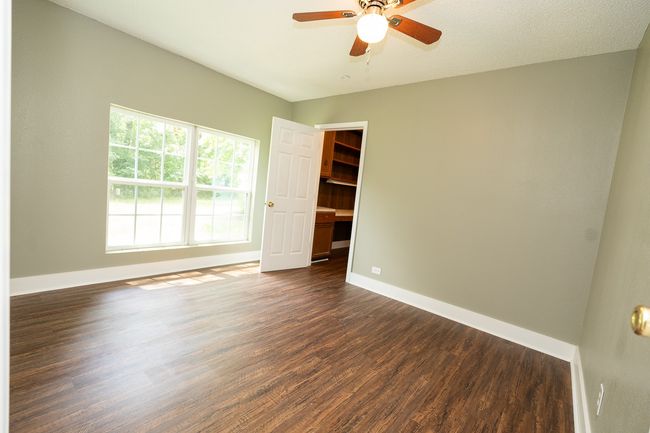 Empty room featuring a ceiling fan and dark wood finished floors | Image 26