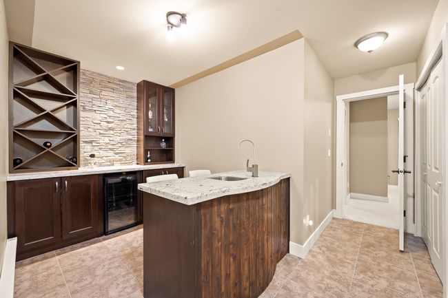 Indoor dry bar featuring beverage cooler and light tile patterned floors | Image 23