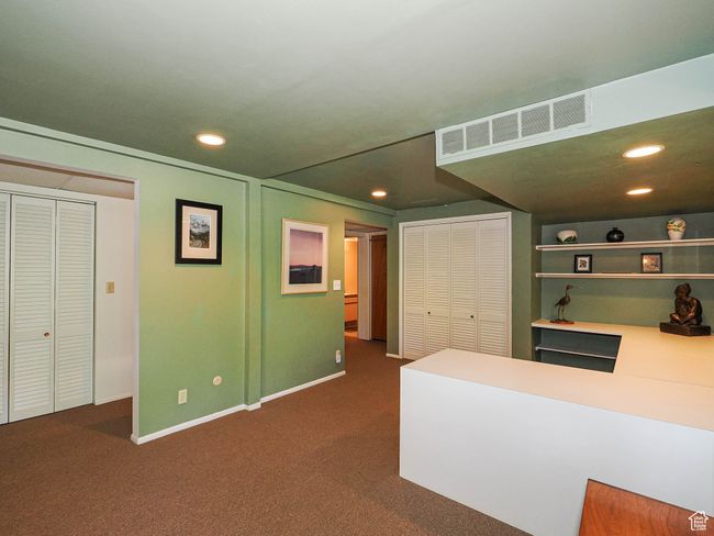 Living area featuring recessed lighting, dark colored carpet, and an office area | Image 54