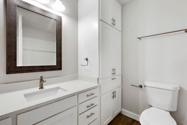 Full bath featuring toilet, baseboards, wood finished floors, and vanity | Image 4