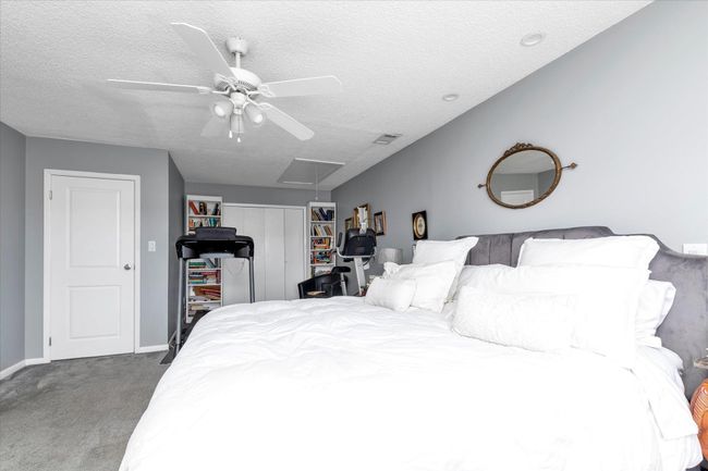 Bedroom with a closet, visible vents, carpet, a textured ceiling, and attic access | Image 11