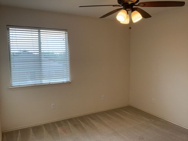 Bedroom with light colored carpet and a ceiling fan | Image 16