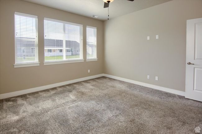 Unfurnished room featuring carpet floors, baseboards, a ceiling fan, and visible vents | Image 12