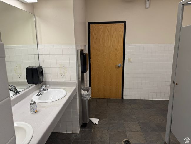 Full bath with a sink, tile walls, and a wainscoted wall | Image 10