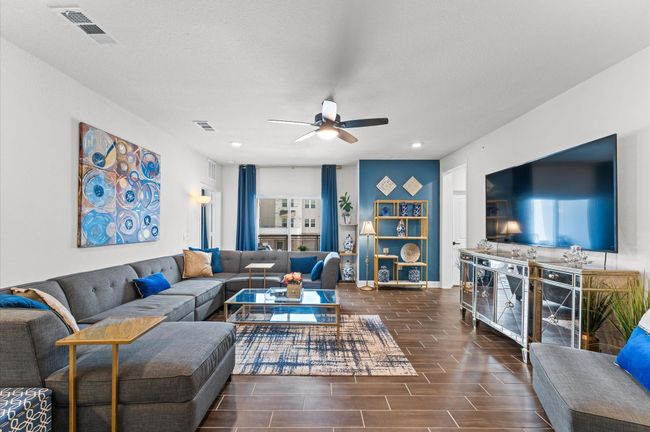 Elegant yet cozy, this living space is anchored by a custom media console, designer shelving, and bold accent wall. | Image 8