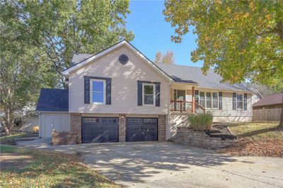 View of front of house with covered porch and a garage | Image 1