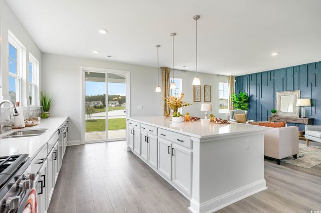 Kitchen featuring gas stove, light wood finished floors, white cabinetry, recessed lighting, and light countertops | Image 8