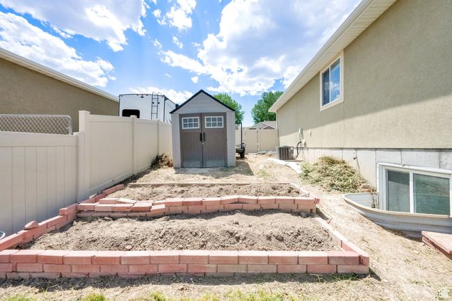 Fenced backyard featuring a storage unit | Image 28