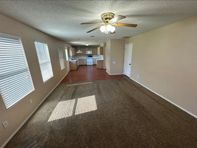 Unfurnished room with sink, carpet, ceiling fan, and a textured ceiling | Image 8