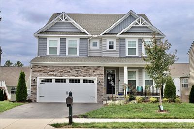 Craftsman-style house featuring a front yard, a garage, and covered porch | Image 1