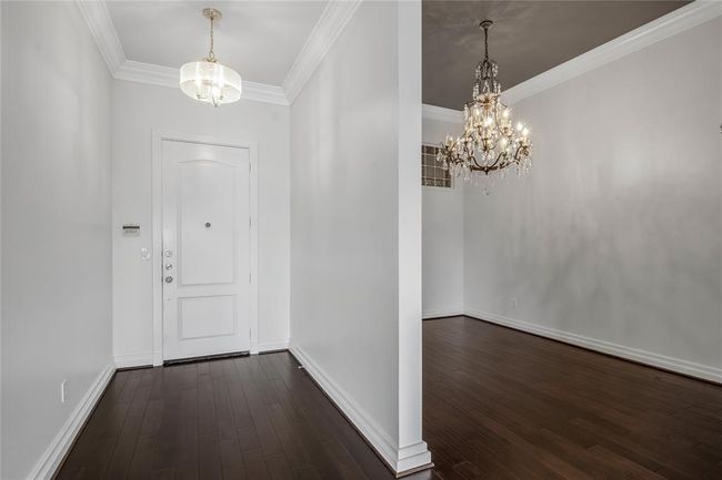 On the left is the small foyer with a beautiful light fixture. To your right is the formal dining room with an elegant chandelier. | Image 11