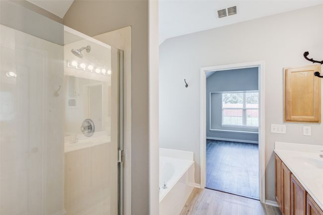 Full bath with a stall shower, a bath, vanity, and wood finished floors | Image 20
