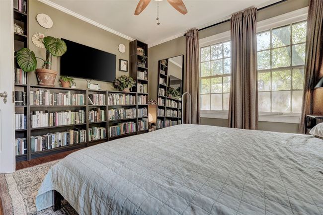 Bedroom with wood finished floors and crown molding | Image 17