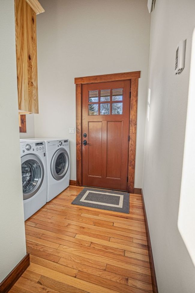 Laundry room with light wood-style floors, washing machine and dryer, and baseboards | Image 16