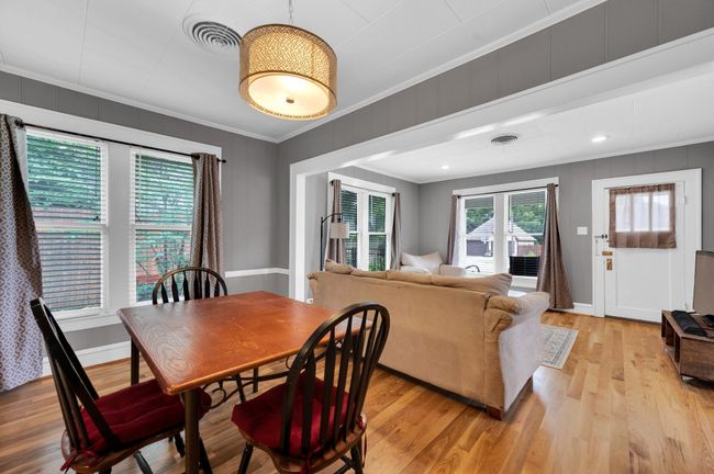 Dining area with healthy amount of natural light, ornamental molding, light wood-style floors, and baseboards | Image 15