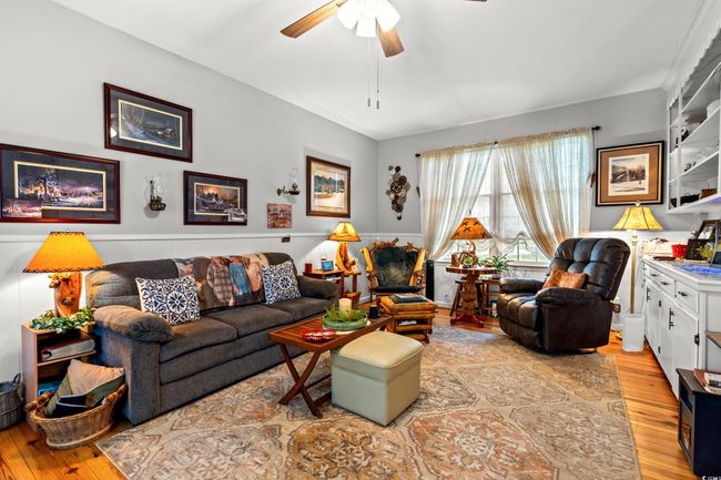 Living area with ceiling fan, light wood-type flooring, and wainscoting | Image 8