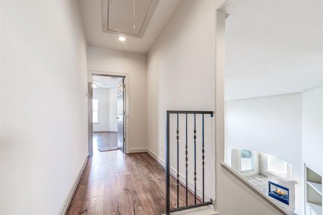 Upper level landing with updated iron railing and continuous wood flooring. | Image 40