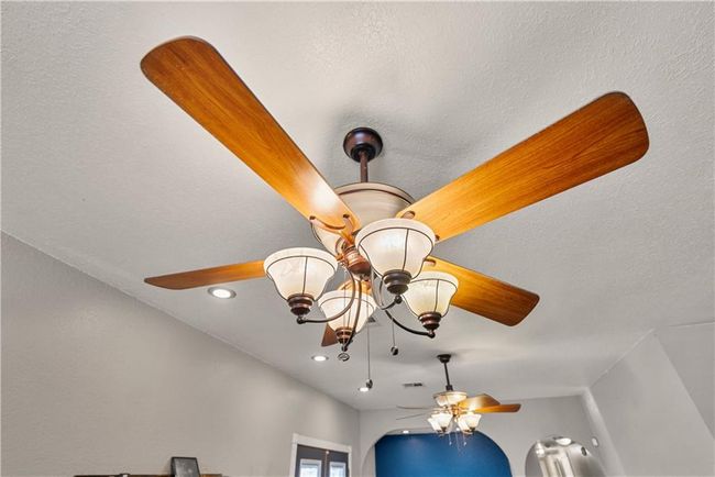 Interior details featuring ceiling fan with notable chandelier | Image 21