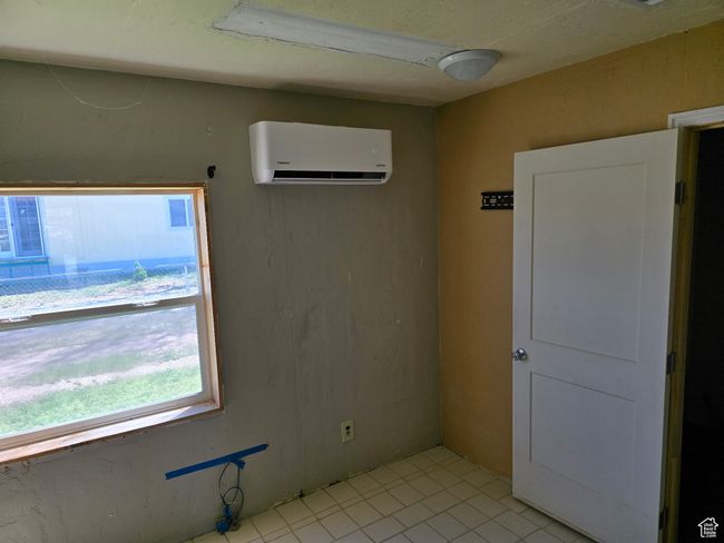 Unfurnished room with an AC wall unit, a healthy amount of sunlight, and light tile patterned floors | Image 11