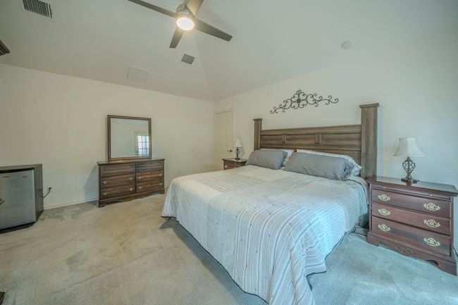 Bedroom with light carpet, a ceiling fan, and high vaulted ceiling | Image 18