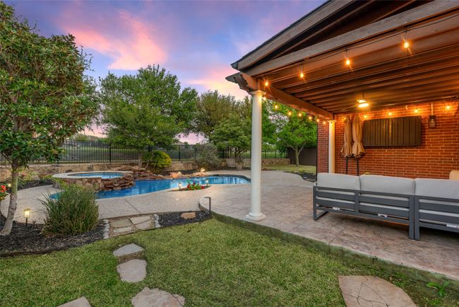 View of swimming pool with outdoor lounge area, a patio, a fenced backyard, and an in ground hot tub | Image 28