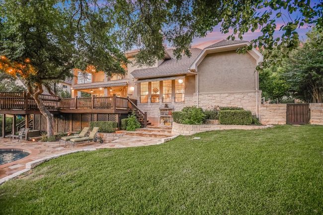 Back of property at dusk with stairs, a deck, stucco siding, and a patio area | Image 35