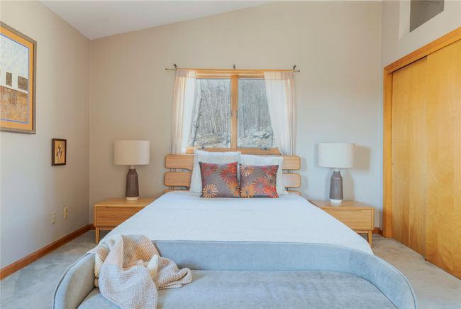Carpeted bedroom with baseboards and lofted ceiling | Image 24