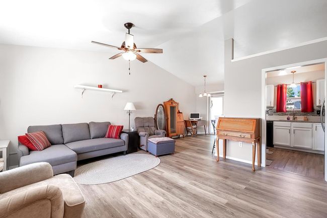 Living area with light wood-style floors, a ceiling fan, and high vaulted ceiling | Image 7