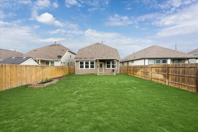 Back of house featuring a lawn, a fenced backyard, and a garden | Image 21