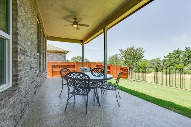 Fenced backyard featuring a patio area, ceiling fan, and outdoor dining space | Image 23