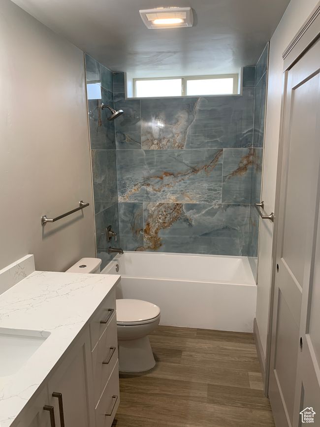 Bathroom with toilet, shower / bath combination, wood finished floors, and vanity | Image 18