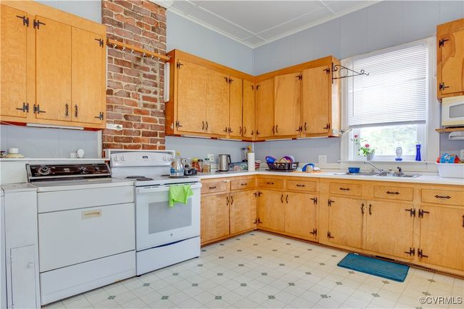 Eat-In kitchen with wood cabinets, Refrigerator, electric stove, washer & Dryer, vinyl floors, & countertops | Image 28