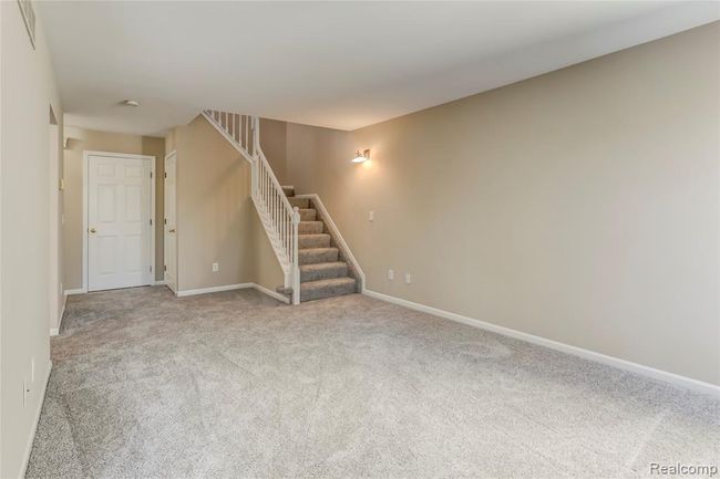 Great room with new paint, carpeting and stairs leading to upper level. | Image 3