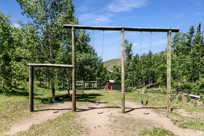 View of yard featuring a playground and a mountain view | Image 28