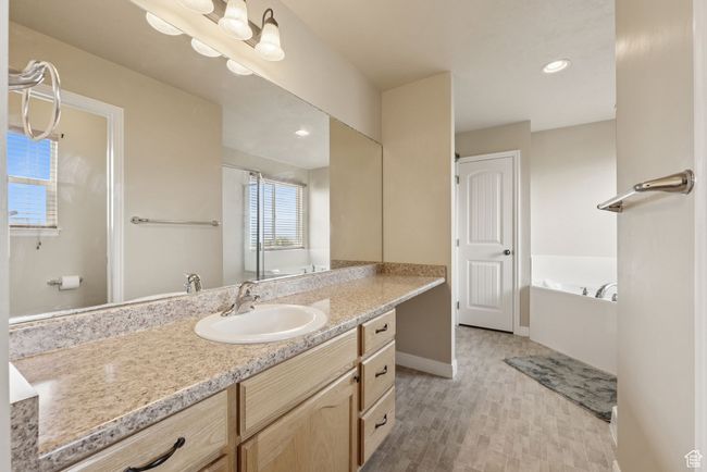 Primary Bathroom featuring vanity, a bath, wood finished floors, and recessed lighting | Image 27