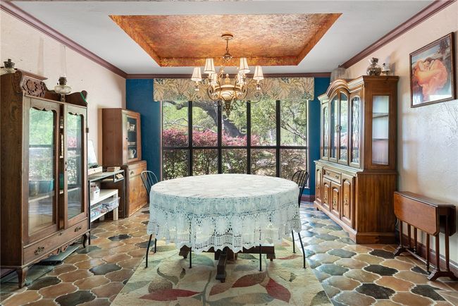 Dining space with stone floors, an inviting chandelier, and a raised ceiling | Image 23