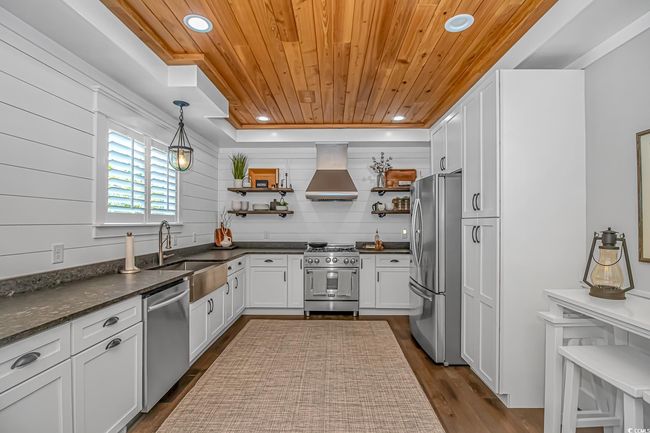 Kitchen featuring appliances with stainless steel finishes, open shelves, exhaust hood, wood ceiling, and recessed lighting | Image 8