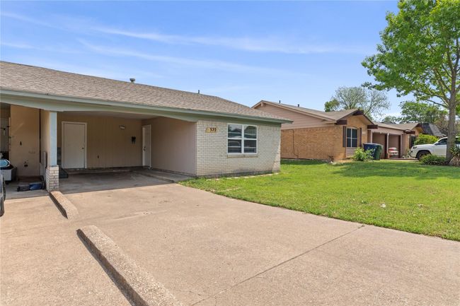 View of front of home with a front yard, driveway, a carport, brick siding, and roof with shingles | Image 4