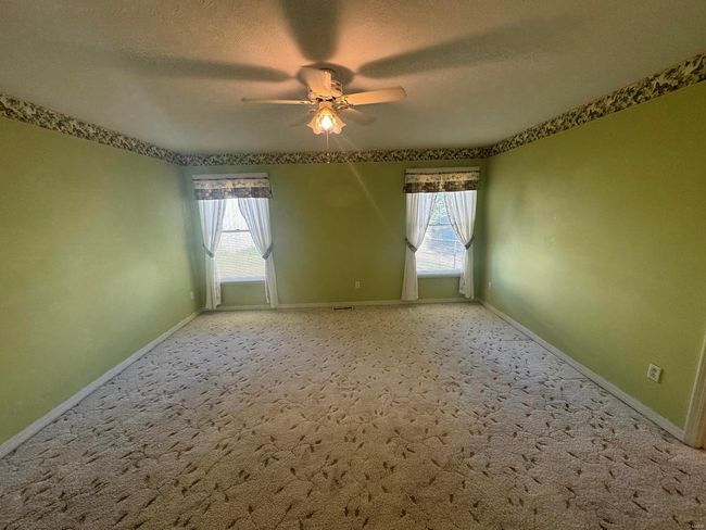 Carpeted spare room with ceiling fan, a textured ceiling, and plenty of natural light | Image 12