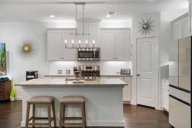 Kitchen with stainless steel appliances, dark wood finished floors, tasteful backsplash, light stone countertops, and recessed lighting | Image 6