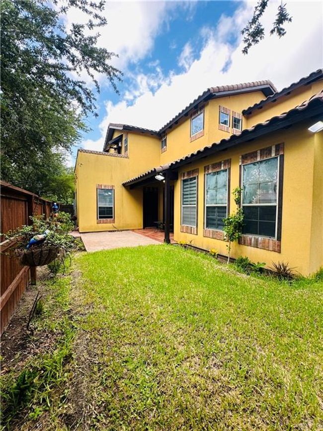 Rear view of house with stucco siding, a patio area, and a tile roof | Image 26
