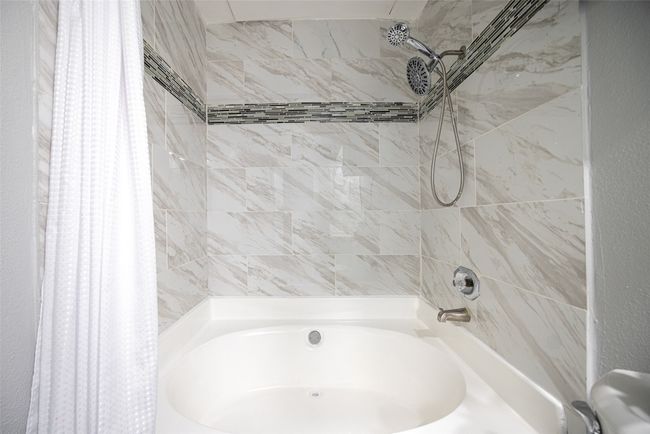 Upgraded bathroom with tile and large updated bathroom tub. | Image 13