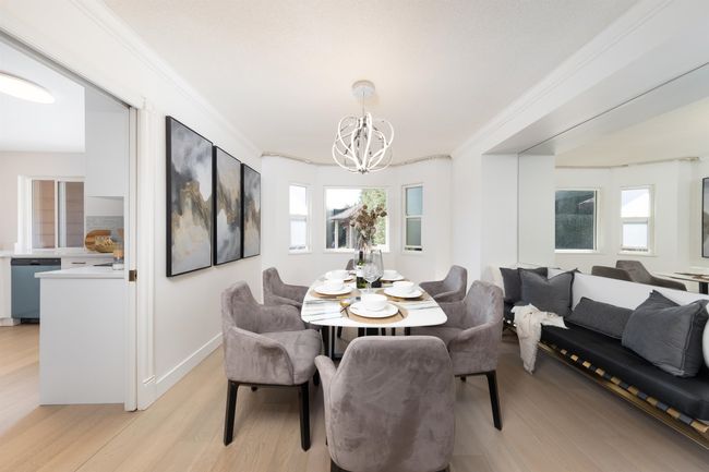 Dining area with baseboards, crown molding, light wood-style flooring, and a chandelier | Image 9