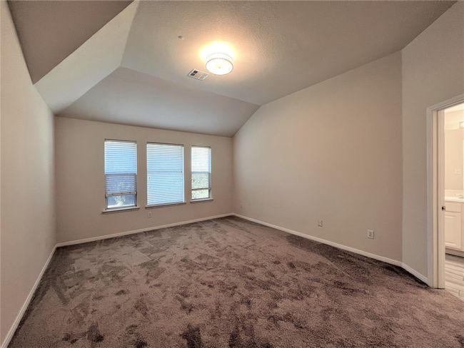 Carpeted empty room with vaulted ceiling and baseboards | Image 9