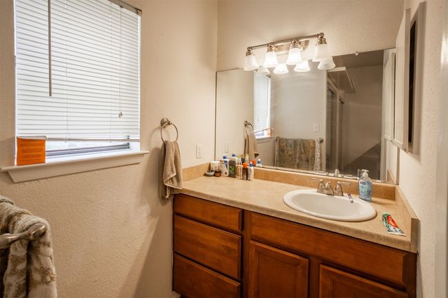 Full bathroom with plenty of natural light, vanity, a shower with shower door, and a textured wall | Image 10