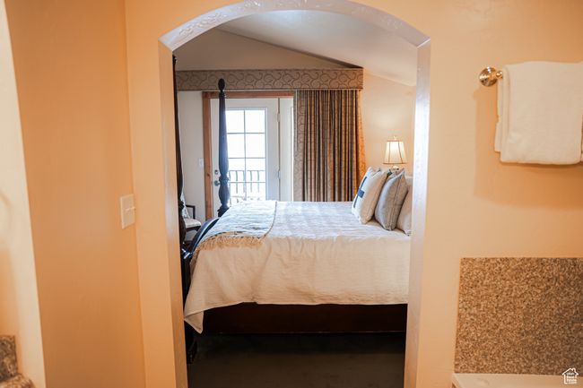 Bedroom with access to exterior, arched walkways, and vaulted ceiling | Image 15
