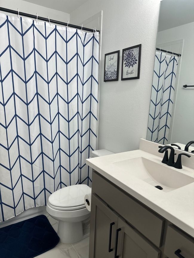 Bathroom featuring toilet, curtained shower, and vanity | Image 36