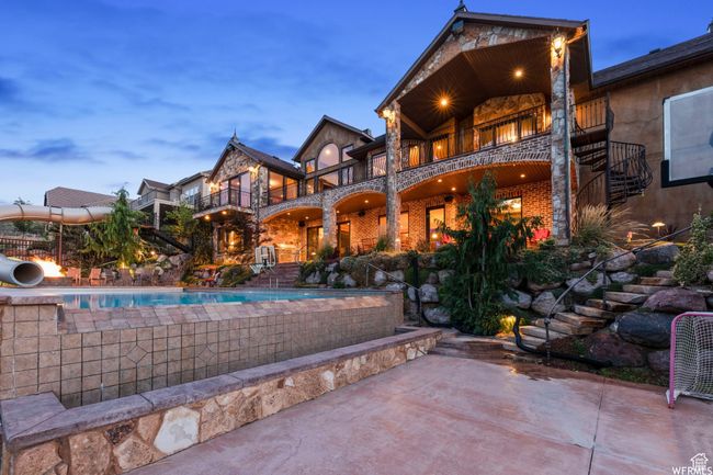 Rear view of property with a patio, brick siding, stairs, and a balcony | Image 5