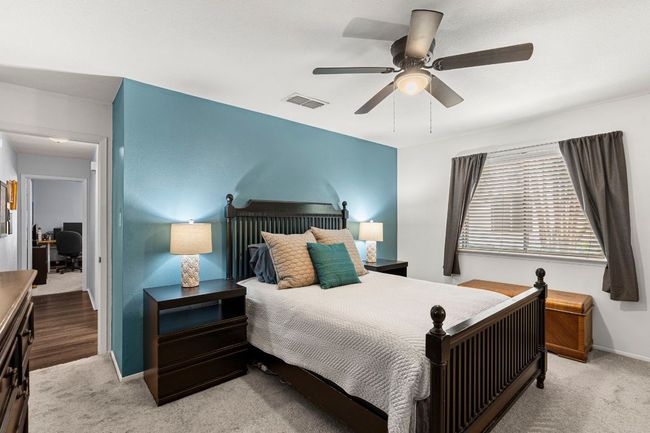 Bedroom with carpet, baseboards, a ceiling fan, and an office area | Image 19